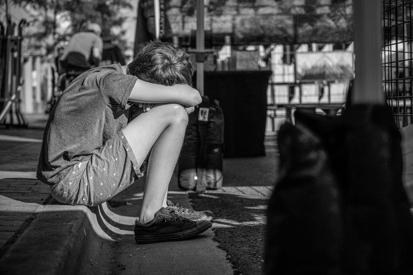 child sitting on curb