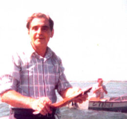 man with fishing rod next to someone in boat